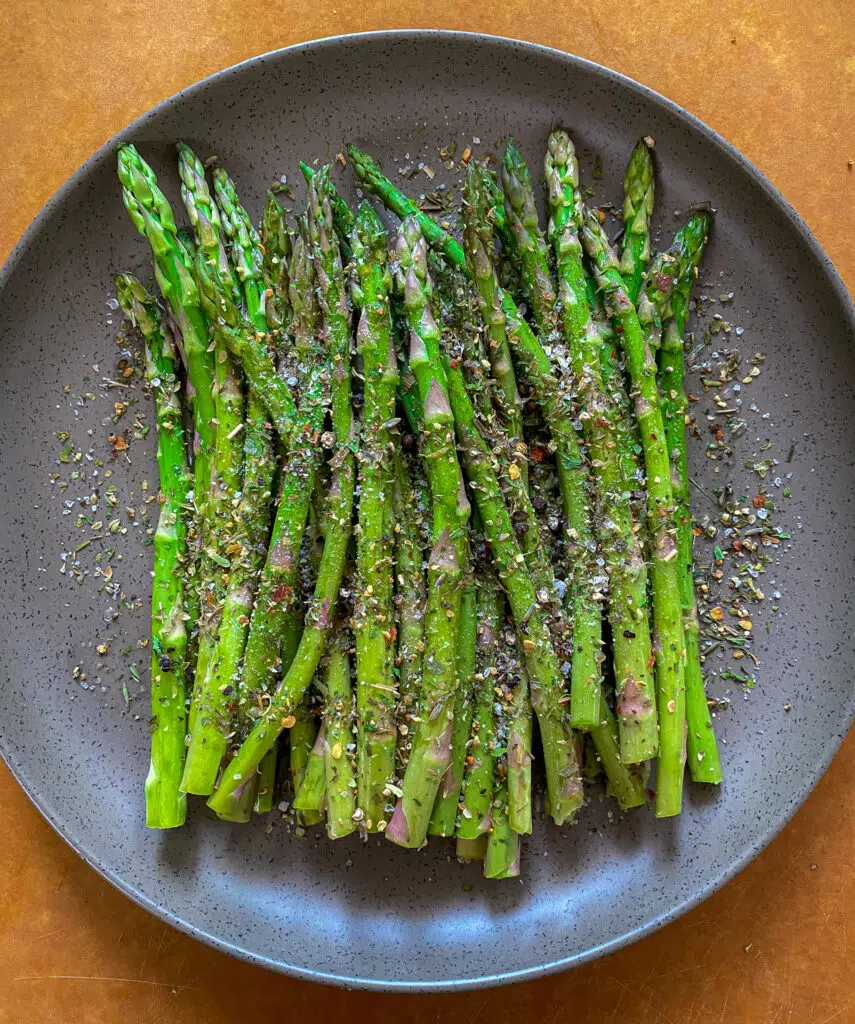 raw asparagus seasoned with salt and Italian seasoning