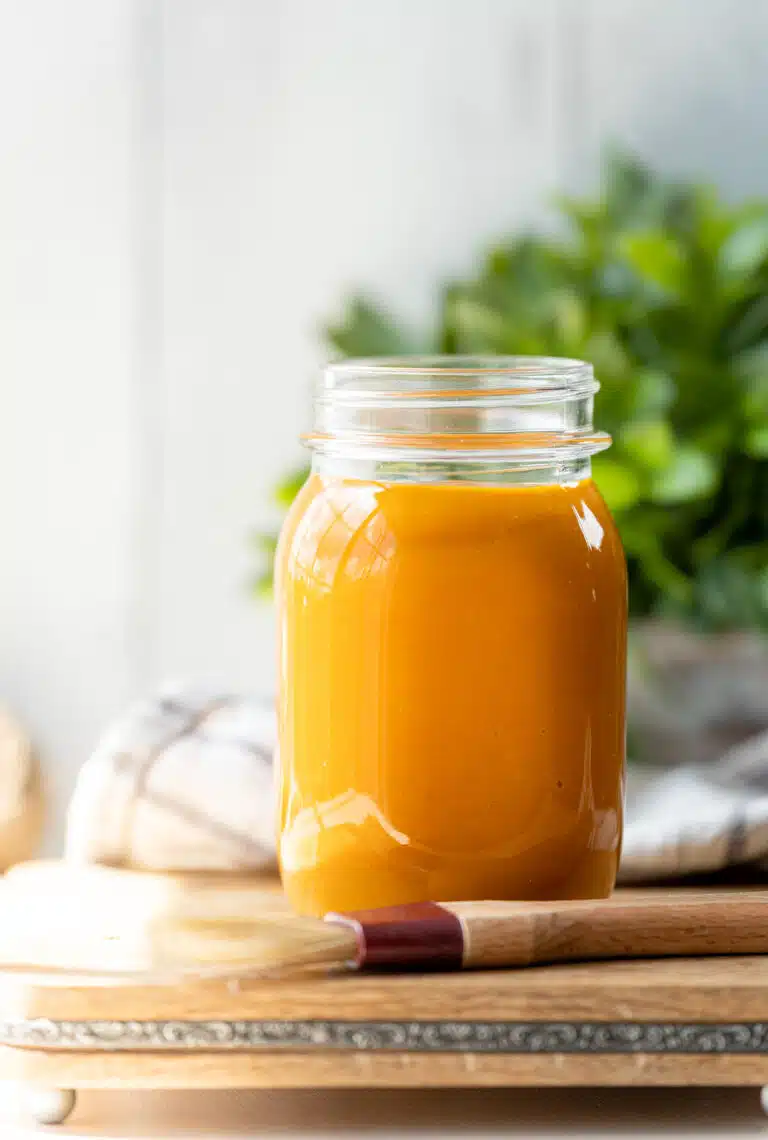 Mason jar filled with golden mustard bbq sauce