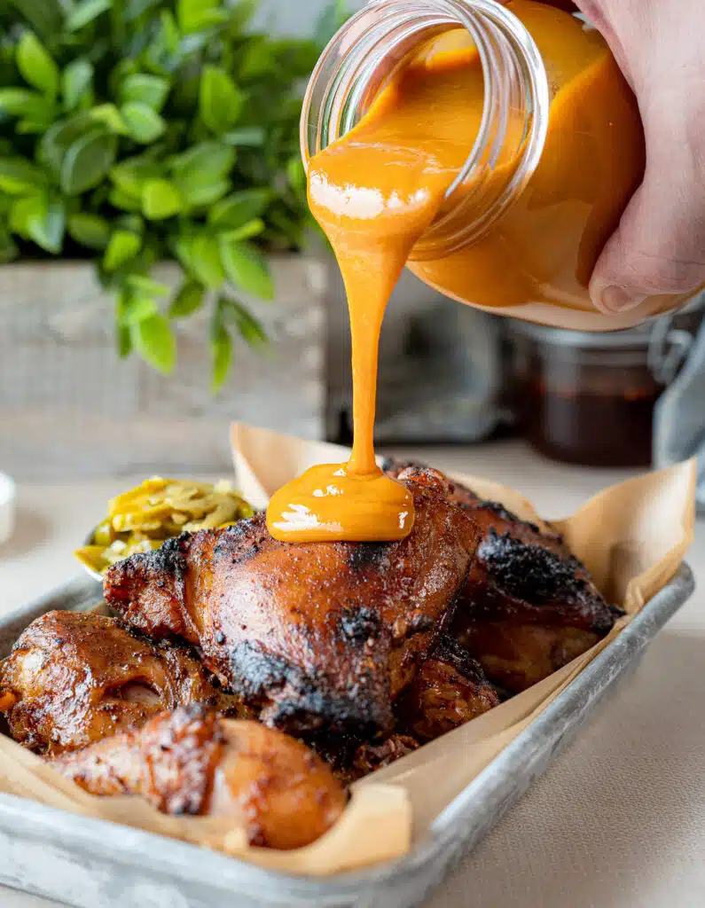 pouring Carolina mustard bbq sauce on chicken