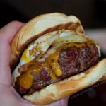 Bacon cheeseburger with a runny egg and fried onions.