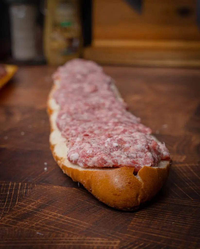 raw bratwurst packed into a loaf of bread