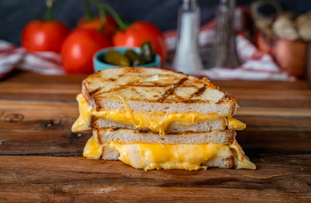 cheese oozing out of a grilled cheese sandwich made on the grill