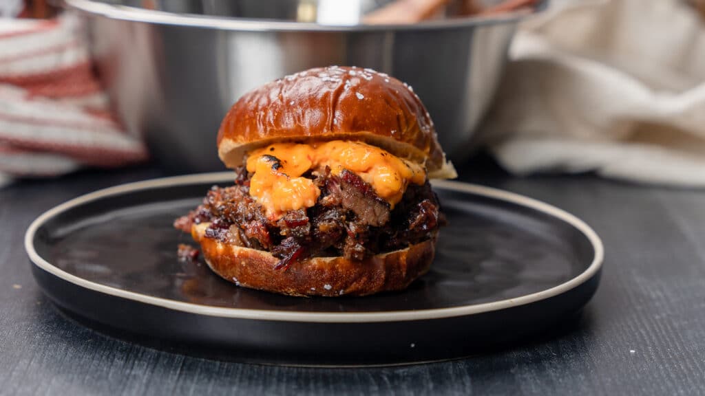 smoked short rib sandwich topped with melted pimento cheese