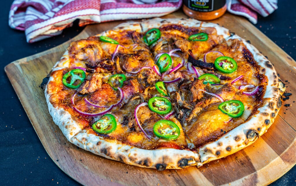 Ooni BBQ Pulled Pork pizza topped with jalapeños and red onions
