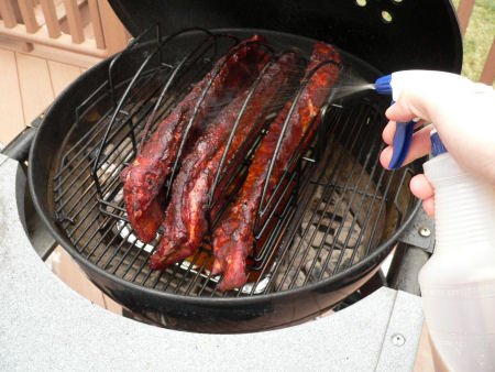 spaying apple cider on to ribs