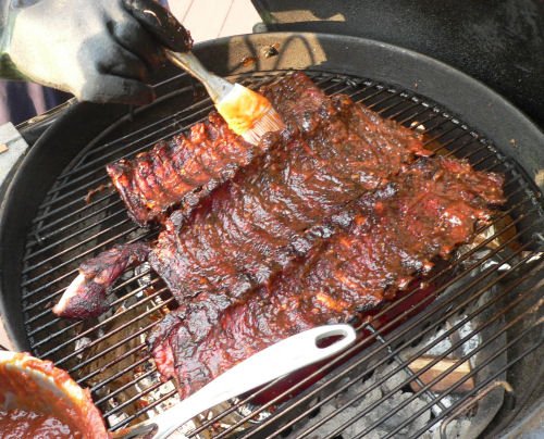 applying a homemade barbecue barbeque sauce to the baby back ribs