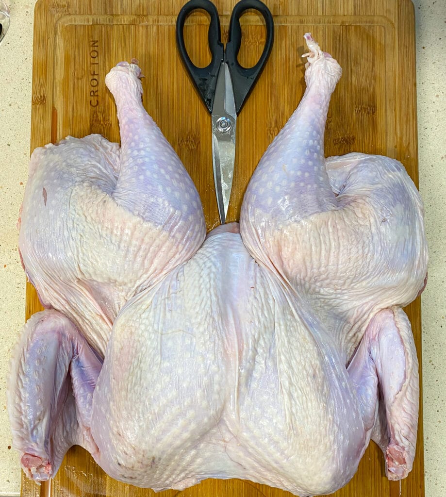 raw spatchcock turkey on a cutting board