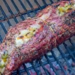 stuffed flank steak rolled up on a grill