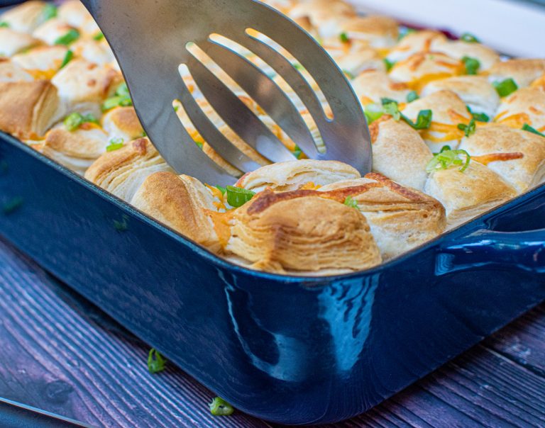 spoon scooping a portion of chicken pot pie topped with biscuits