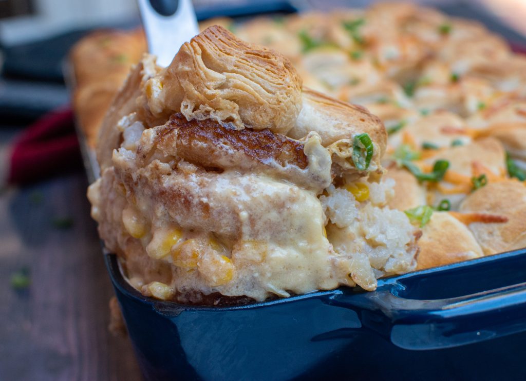 scooping out a serving of chicken pot pie casserole made with biscuits