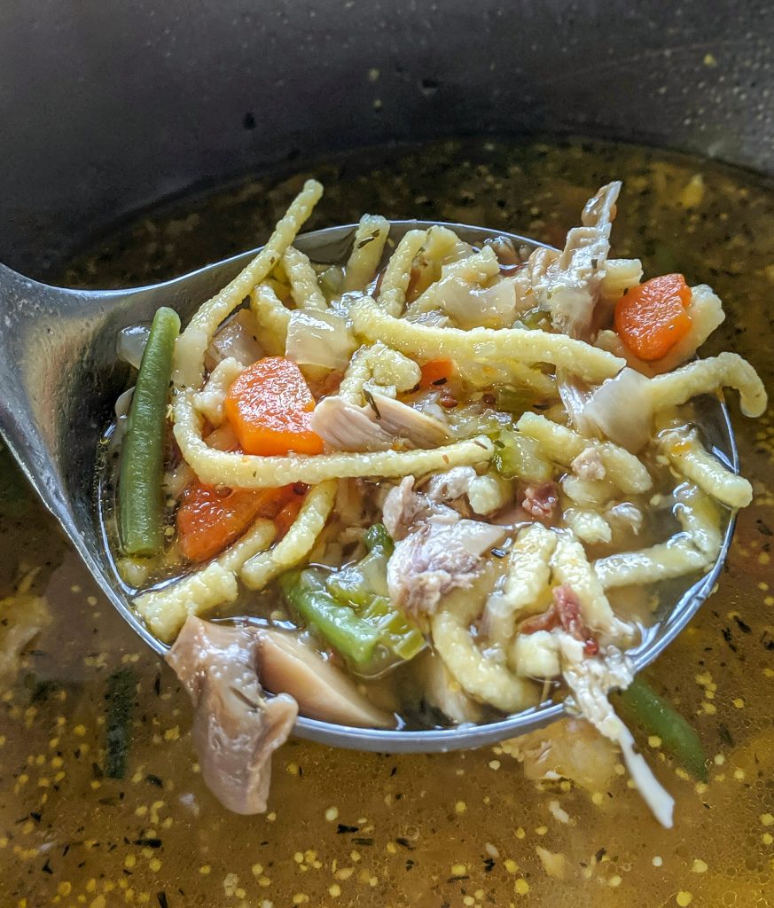 ladle od chicken soup with spaetzle pasta