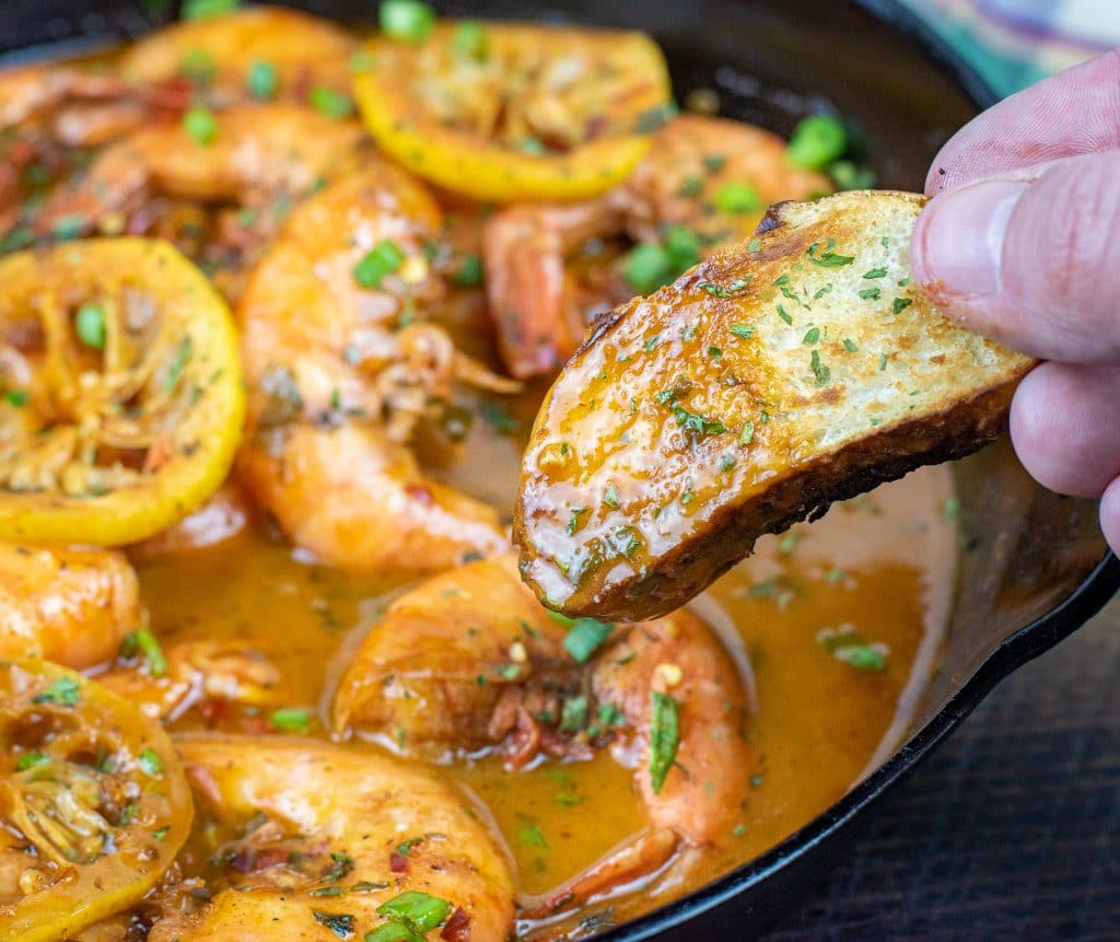 Dipped pretzel bread in butter sauce of New Orleans barbecue shrimp