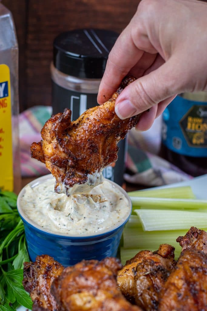 dipped smoked wing in ranch dressing glazed with honey old bay