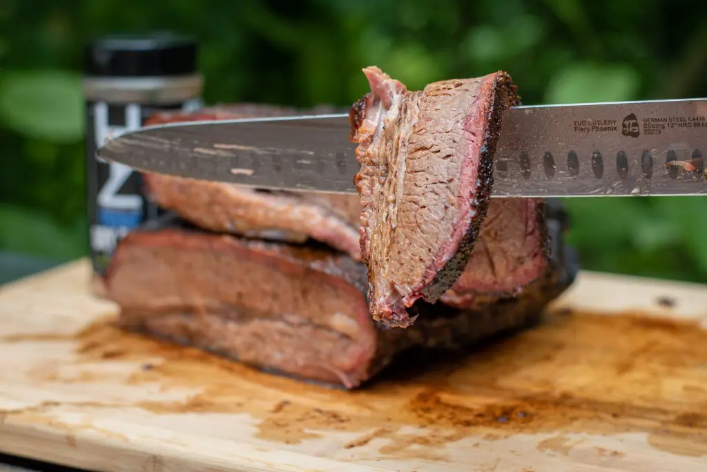 knife holding slice of brisket