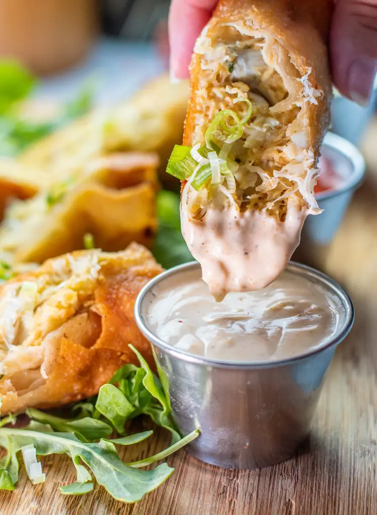dipping crab cake egg roll in old bay aioli