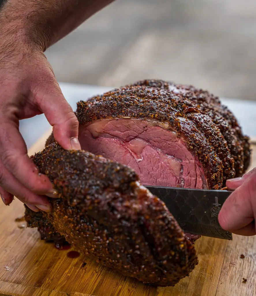 sliced smoked prime rib with a folded steel dahlia chef knife