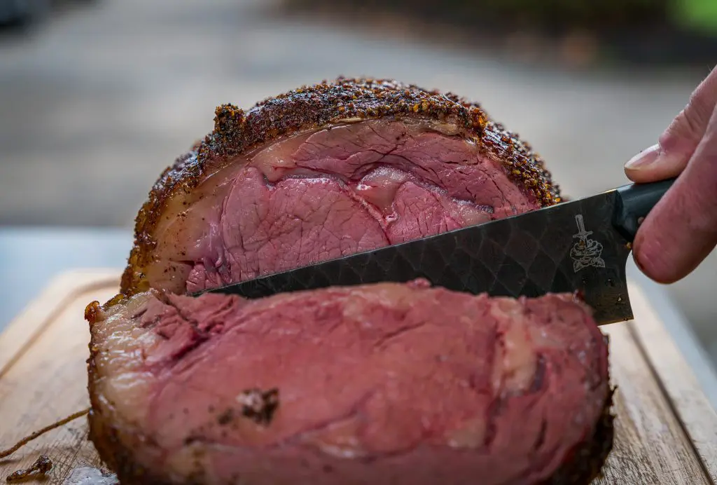 sliced smoked prime rib with a folded steel dahlia chef knife