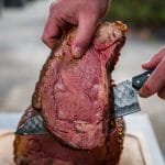 sliced smoked prime rib with a folded steel dahlia chef knife