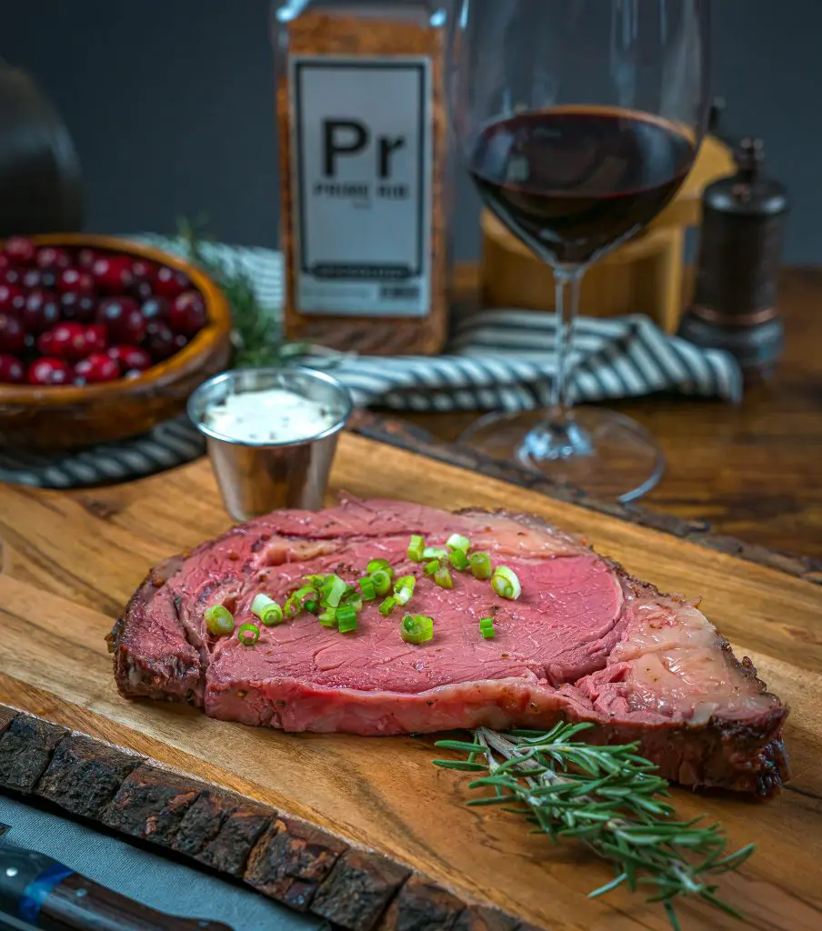 smoked prime rib with a glass of wine and creamy horseradish sauce