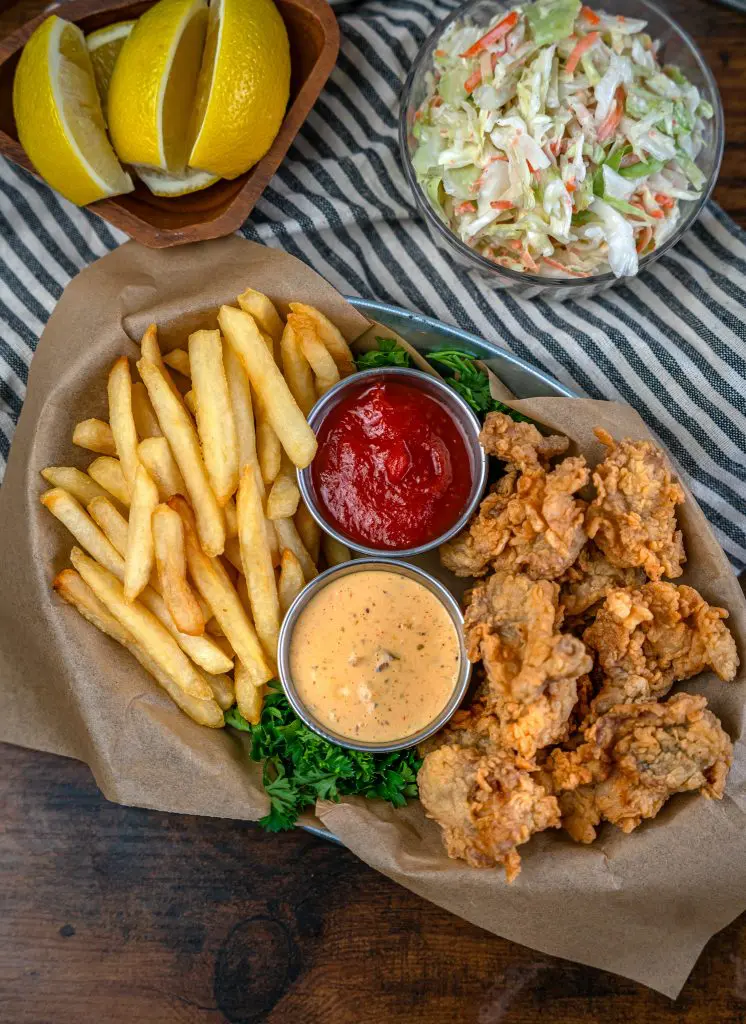 deep fried oysters in a basket with French fries, Coleslaw, cocktail and remoulade