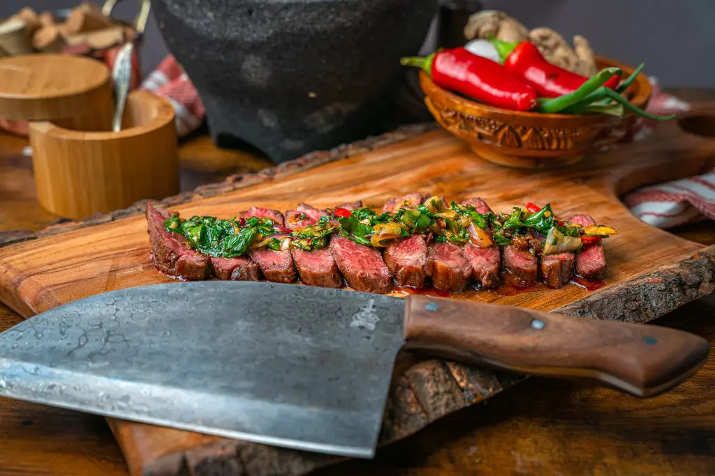 sliced rare Denver Steak topped with chimichurri sauce