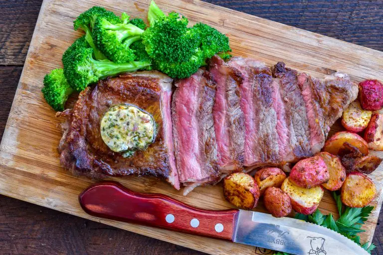 New York strip steak sliced and served with broccoli and garlic compound butter