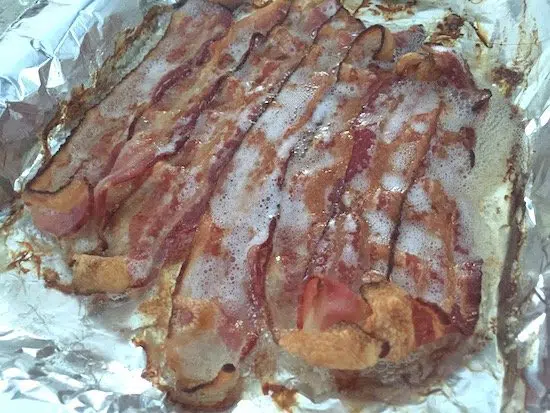 Bacon grease collecting on tin foil during cooking