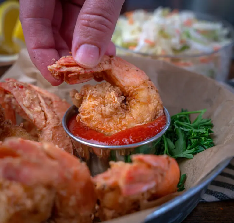 fried shrimp dunked into cocktail sauce