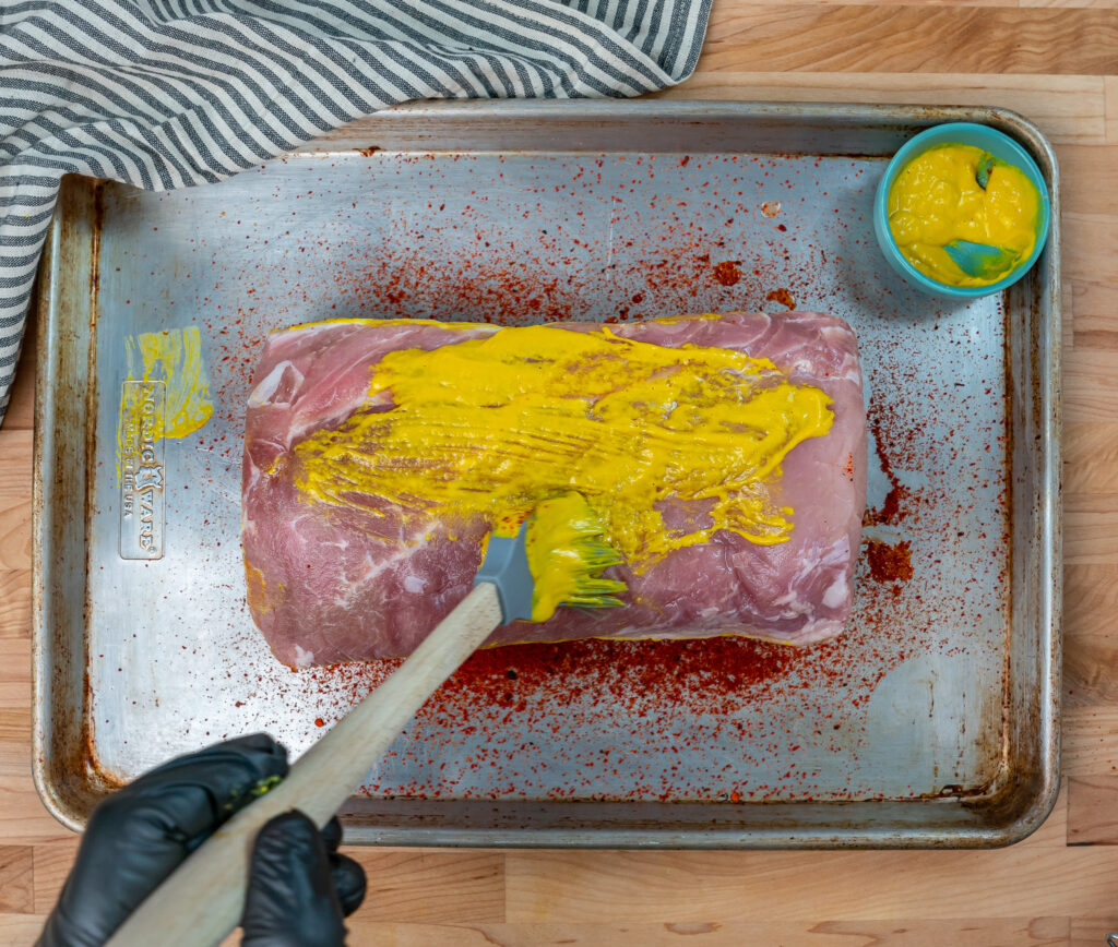 brushing frozen pork loin with mustard