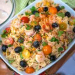 southwestern pasta salad made with farfalle pasta , cheddar cheese, tomatoes and black olives
