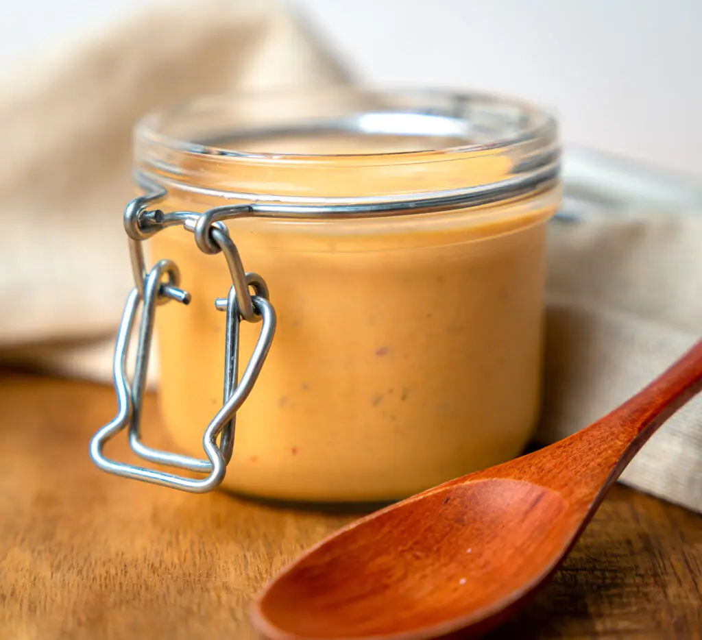 Mississippi comeback sauce in a jar sitting on a cutting board