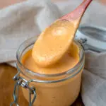 comeback sauce scooped out with a rustic wooden spoon