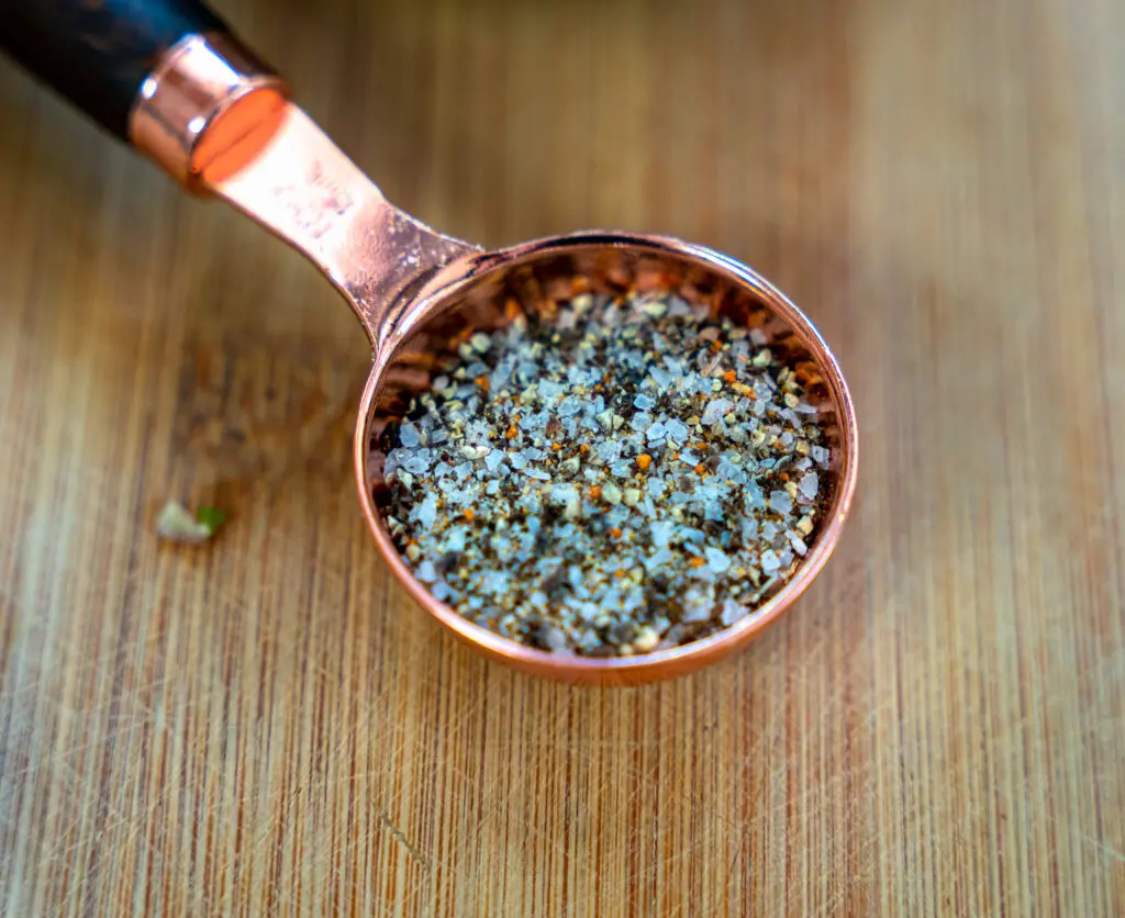close up of beef rub in a copper measuring spoon