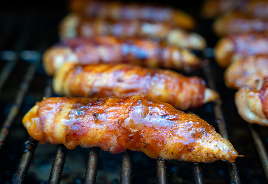 bacon wrapped chicken tenders on a recteq pellet grill