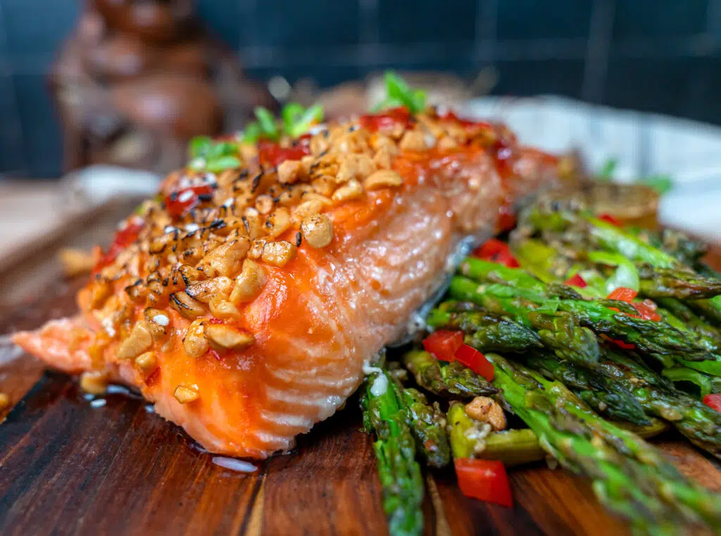 penut crusted salmon leaned onto grilled asparagus