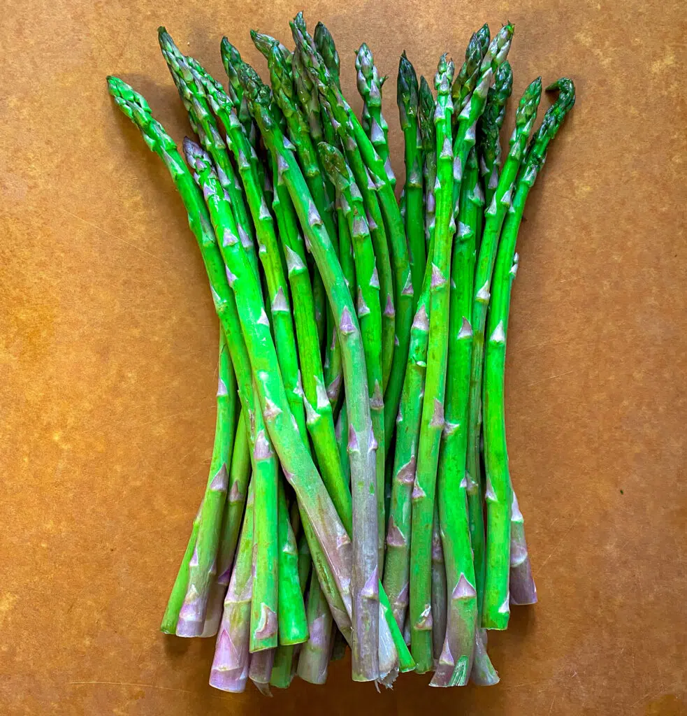 raw asparagus on a cutting board