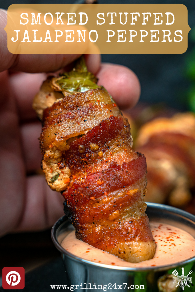 dunking jalapeno pepper wrapped in bacon into spicy ranch