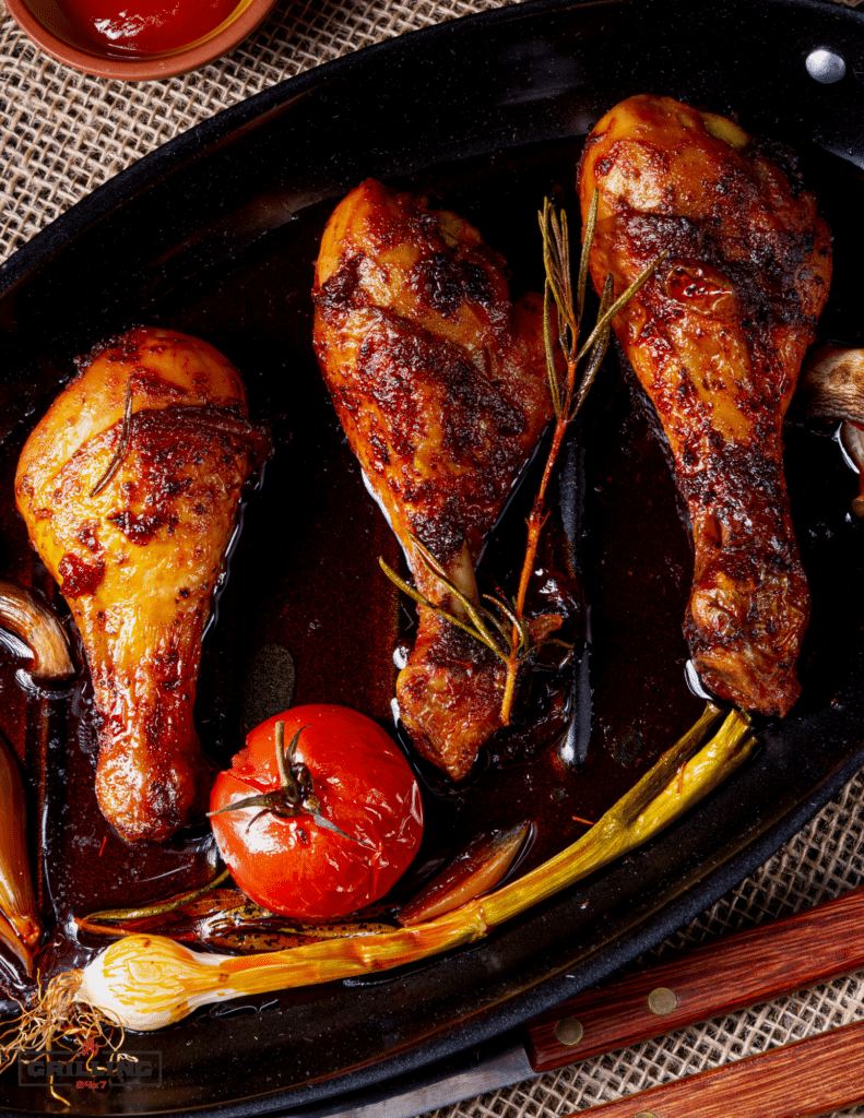 smoked chicken legs in a pan with roasted tomato