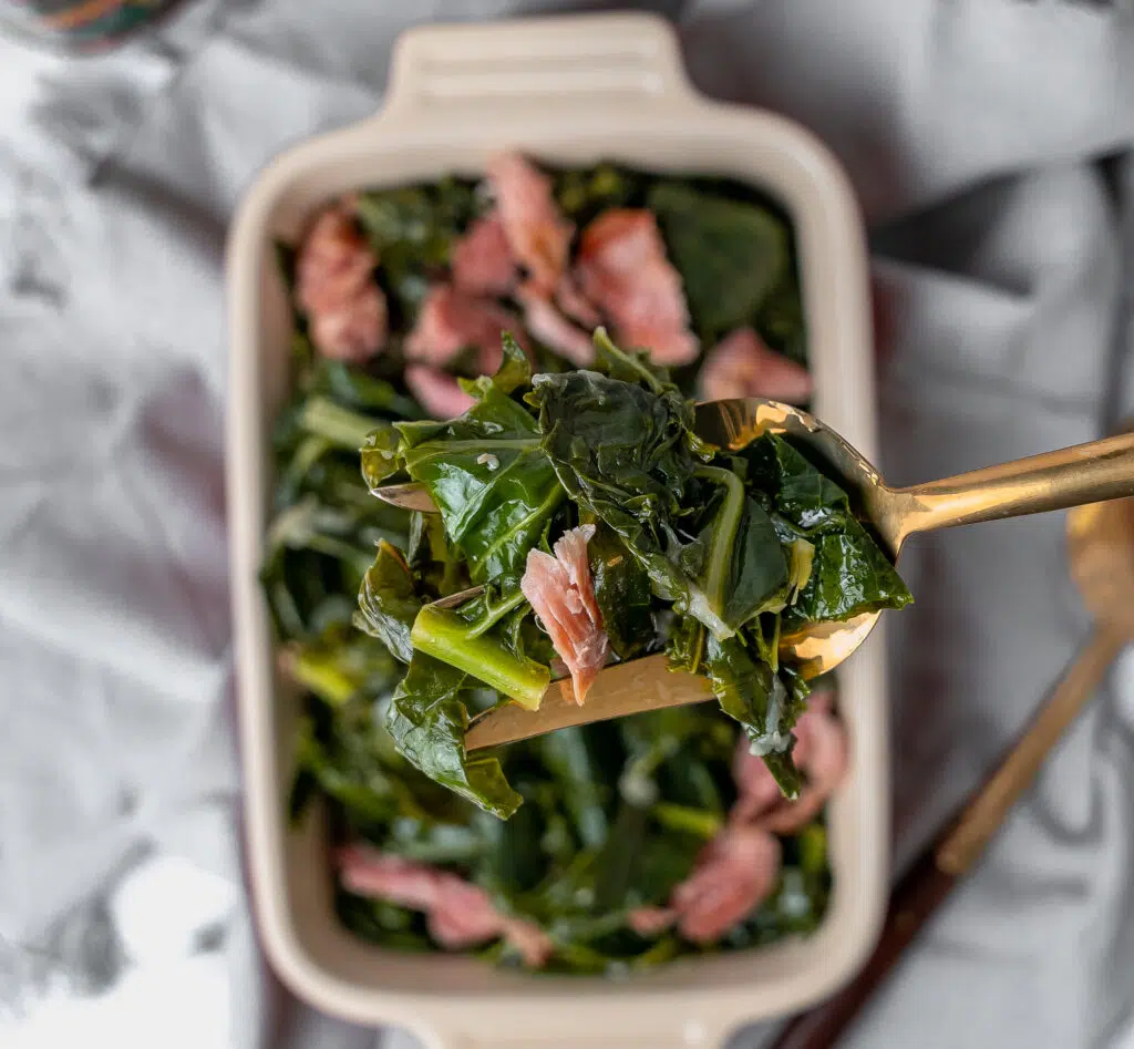 southern collard greens with smoked turkey legs in a casserole dish