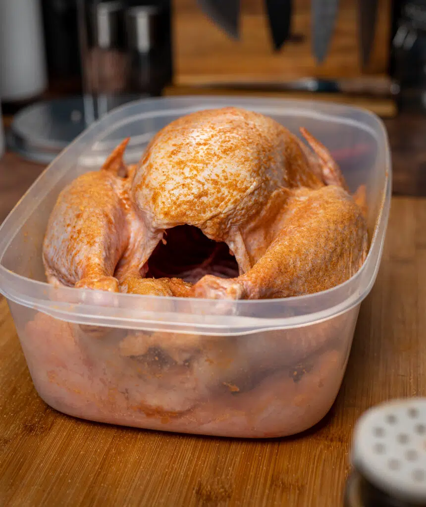 raw turkey seasoned with lawrys season salt in a plastic container