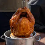 deep fried turkey getting pulled out of the peanut oil