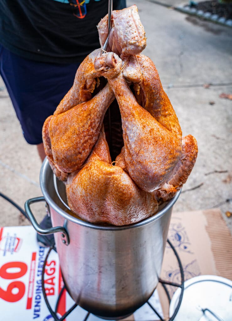 raw turkey being lowered into a pot