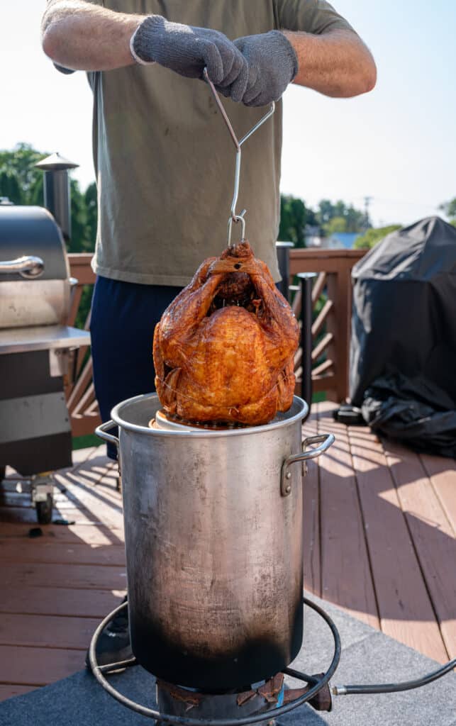 raising the fried turkey out of the fryer pot