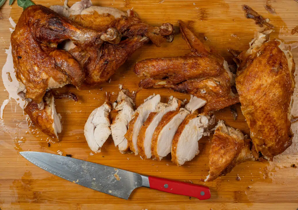 carved deep fried turkey with dark meat and white meat separated on a cutting board