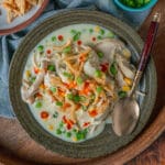 Easy chicken and dumplings recipe topped with crispy onions and hot sauce