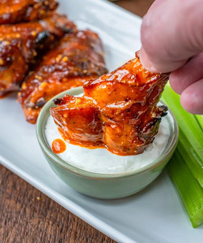 dipping a buffalo win in bleu cheese dressing