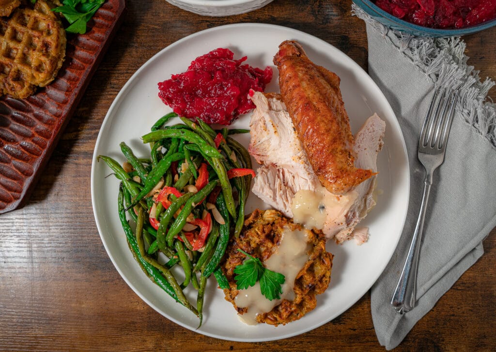thanksgiving plate with cranberry sauce, green beans, stuffing with gravy and turkey