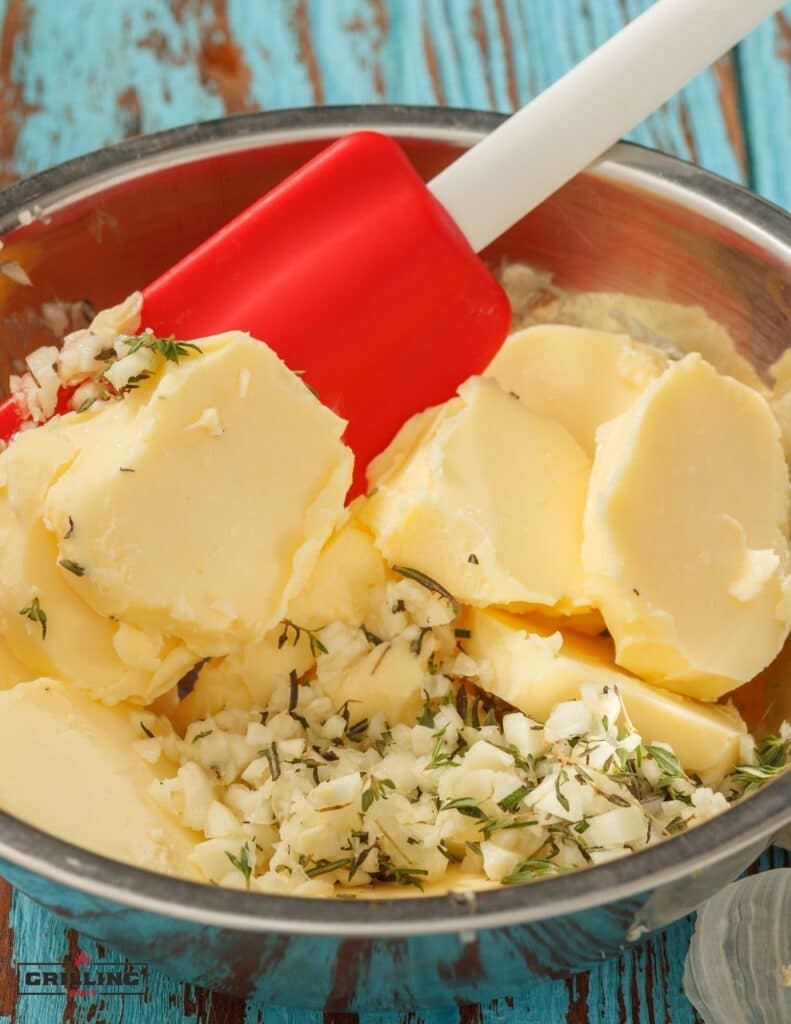 mixing together butter with garlic and herbs