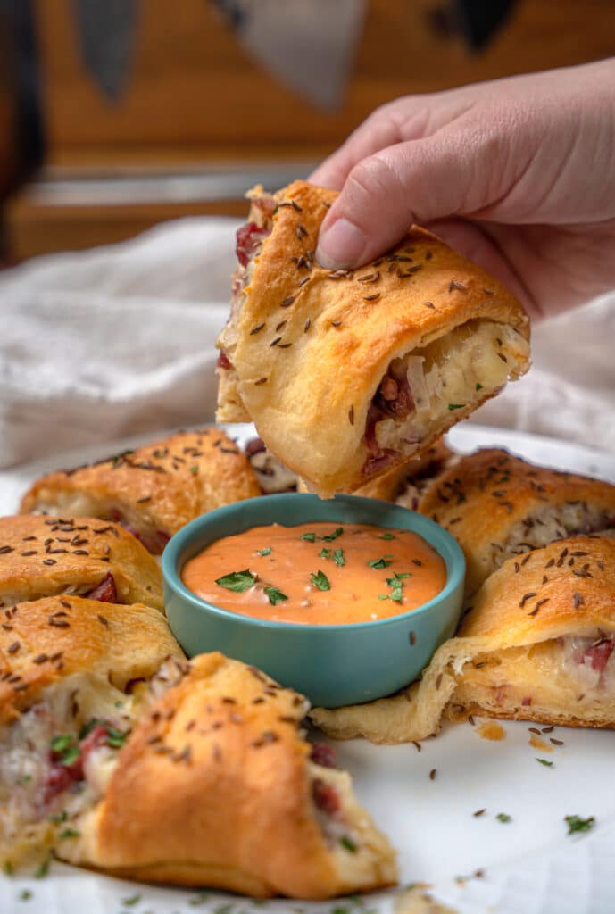 dipping Reuben Crescent Roll into thousand island dressing