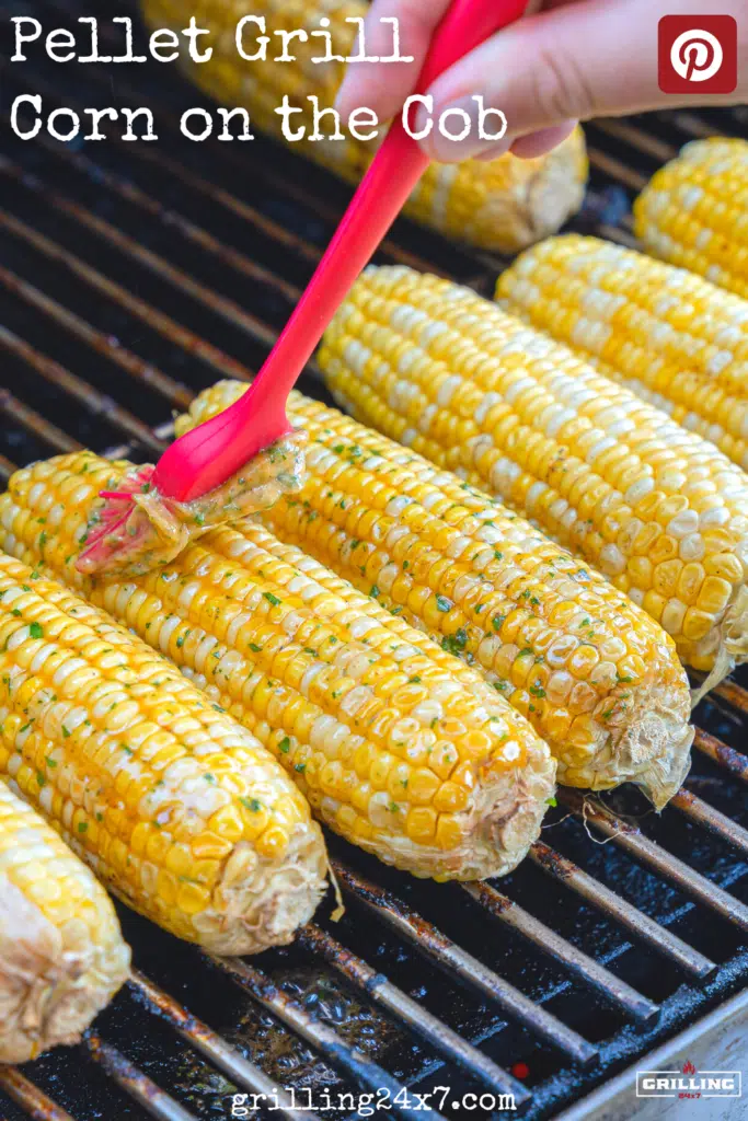 brushing honey and butter on pellet grill corn on the cob on grill